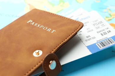 Photo of Passport in brown cover and flight tickets on world map, closeup