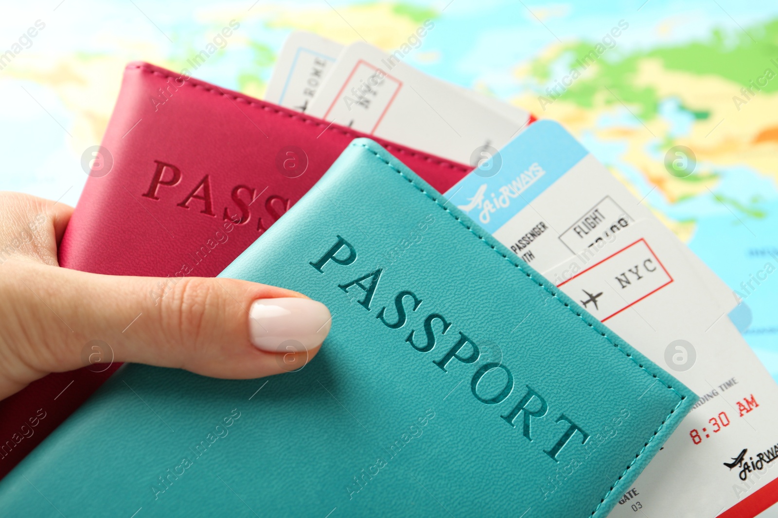 Photo of Woman with passports and flight tickets near world map, closeup