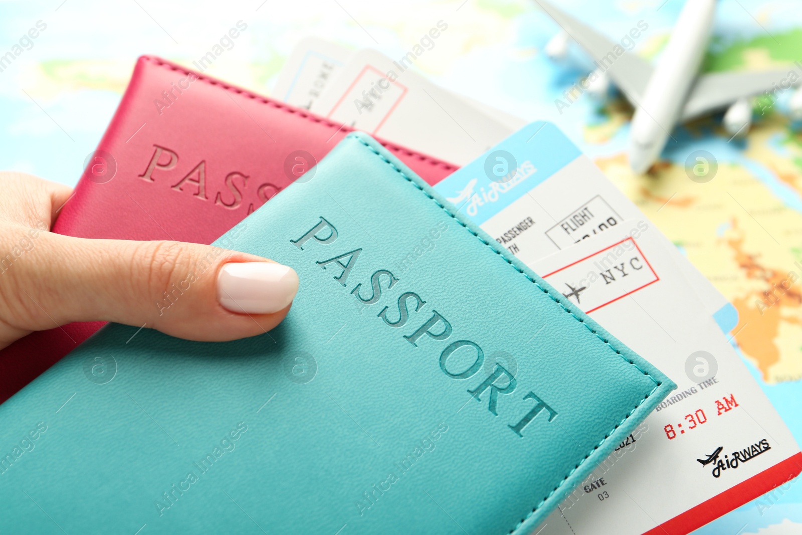 Photo of Woman with passports and flight tickets near world map, closeup