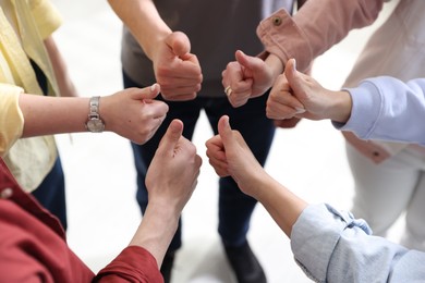 Photo of Unity concept. People showing thumbs up indoors, closeup