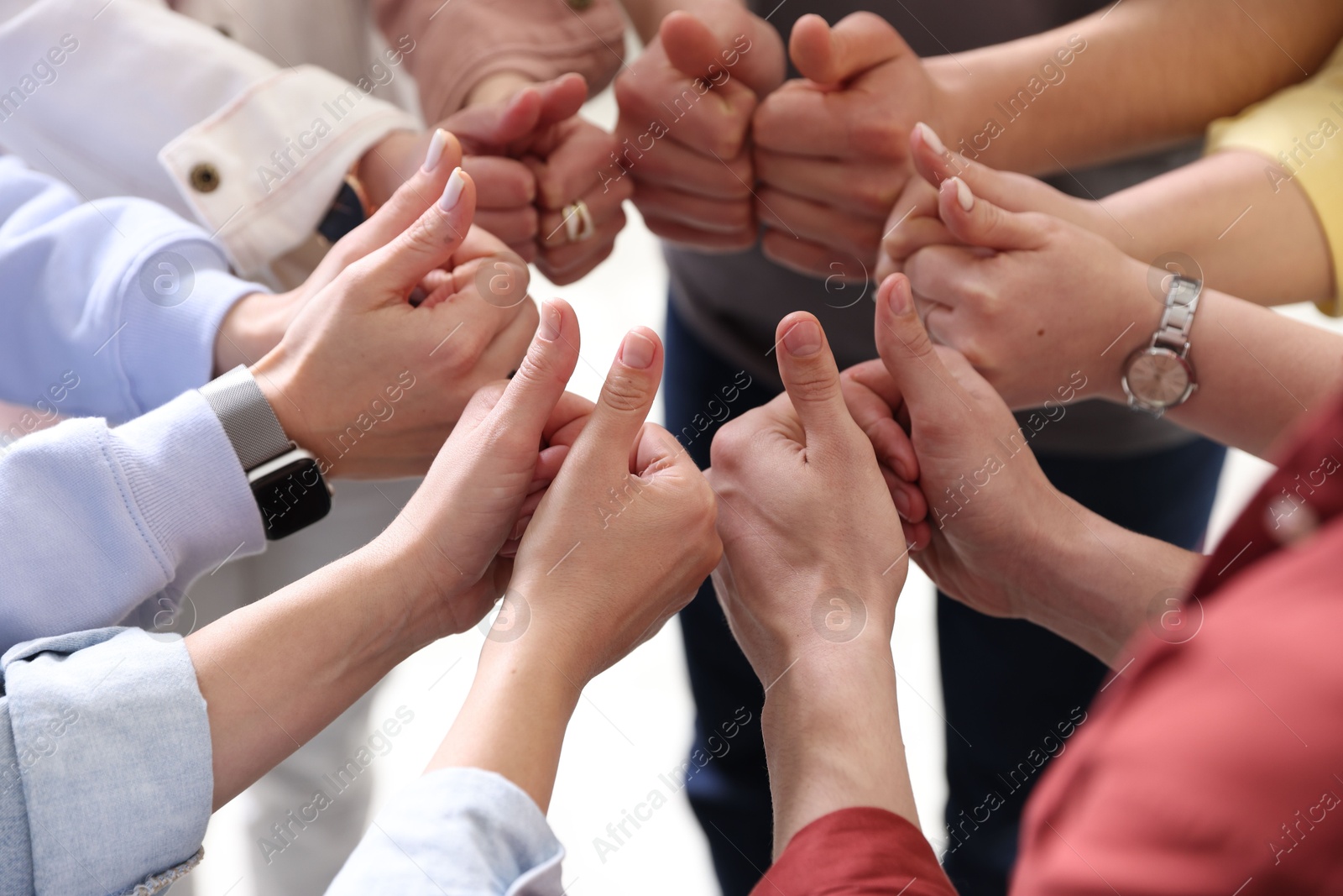 Photo of Unity concept. People showing thumbs up indoors, closeup