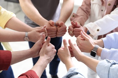 Photo of Unity concept. People showing thumbs up indoors, closeup