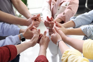 Photo of Unity concept. People showing thumbs up indoors, closeup