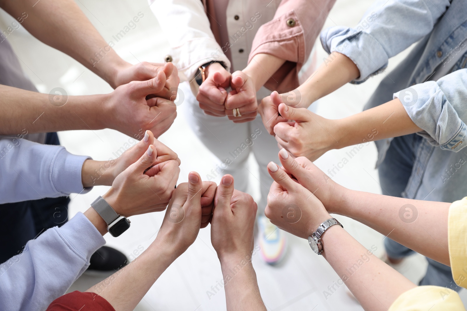 Photo of Unity concept. People showing thumbs up indoors, closeup