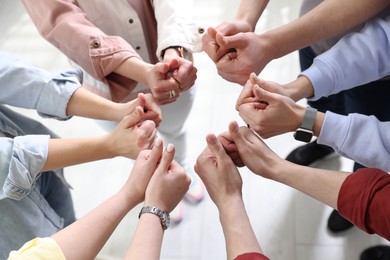 Photo of Unity concept. People showing thumbs up indoors, closeup