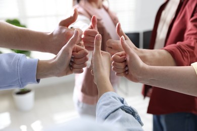 Photo of Unity concept. People showing thumbs up indoors, closeup