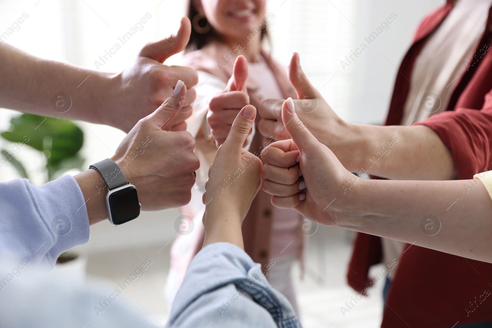 Photo of Unity concept. People showing thumbs up indoors, closeup