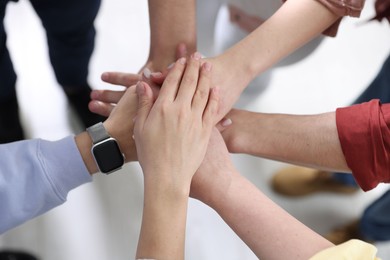 Photo of Unity concept. People holding hands together indoors, above view