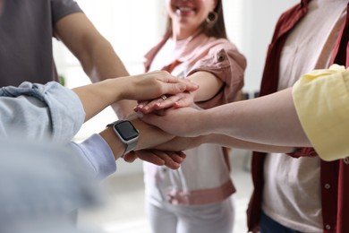 Unity concept. People holding hands together indoors, closeup