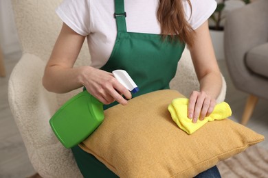 Photo of Janitor cleaning sofa cushion at home, closeup