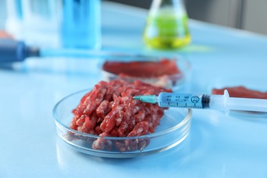 Photo of GMO concept. Minced meat and syringe on table in laboratory, closeup