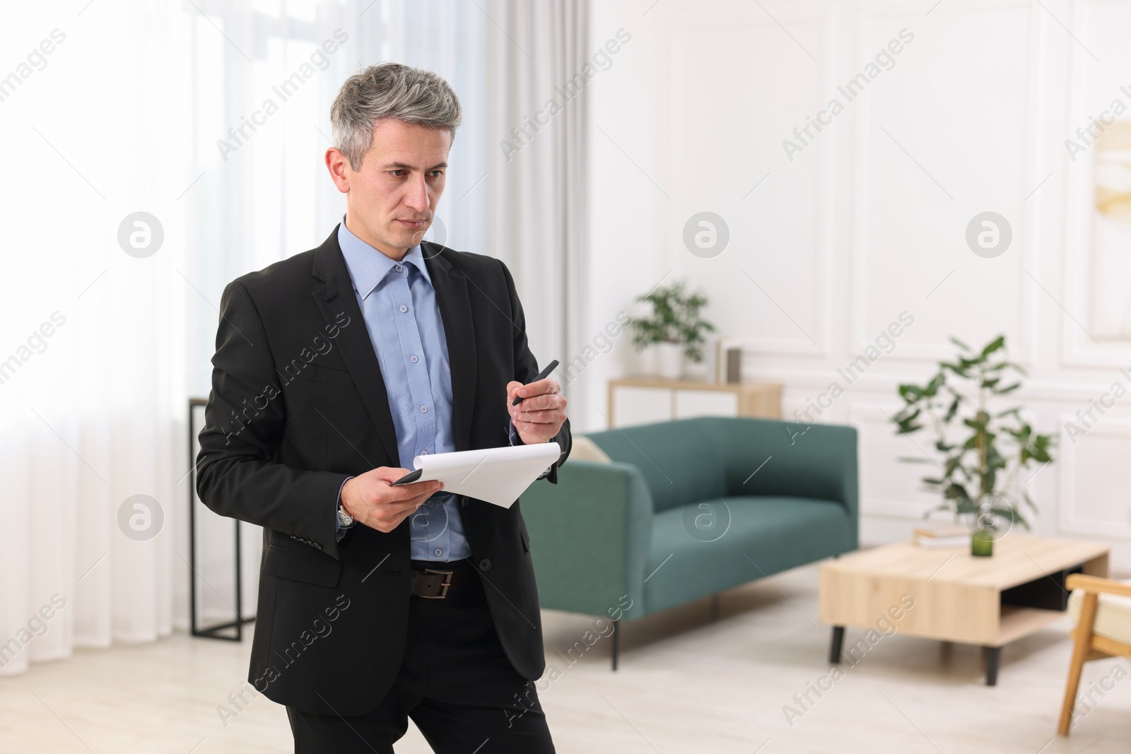 Photo of Real estate appraisal. Inspector with clipboard conducting property valuation at home. Space for text