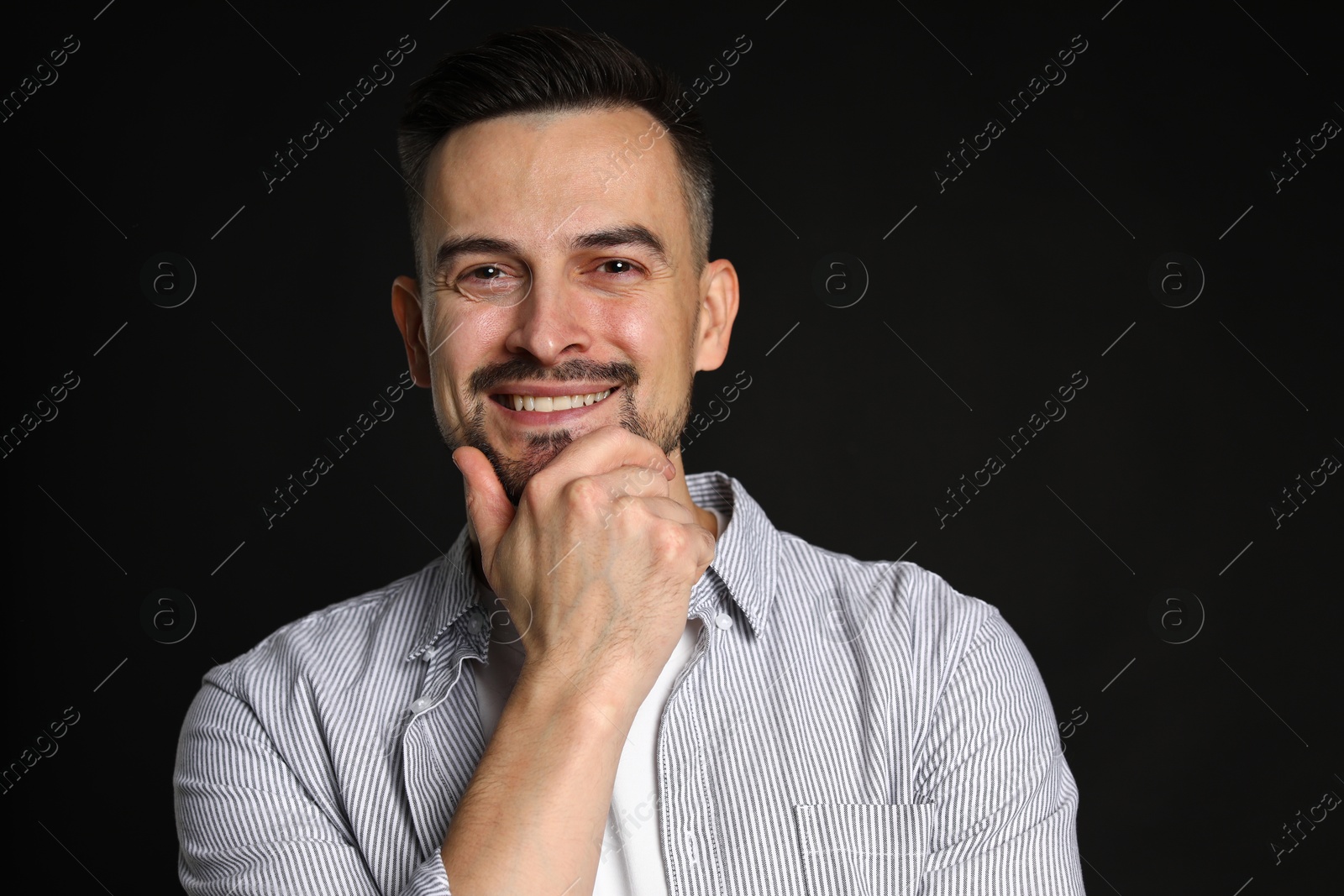 Photo of Portrait of handsome middle aged man on black background