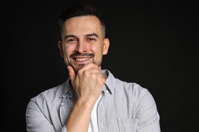 Photo of Portrait of handsome middle aged man on black background