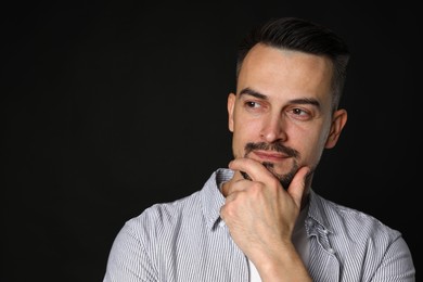 Photo of Portrait of handsome middle aged man on black background, space for text