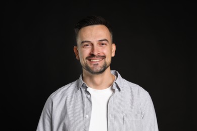 Photo of Portrait of handsome middle aged man on black background