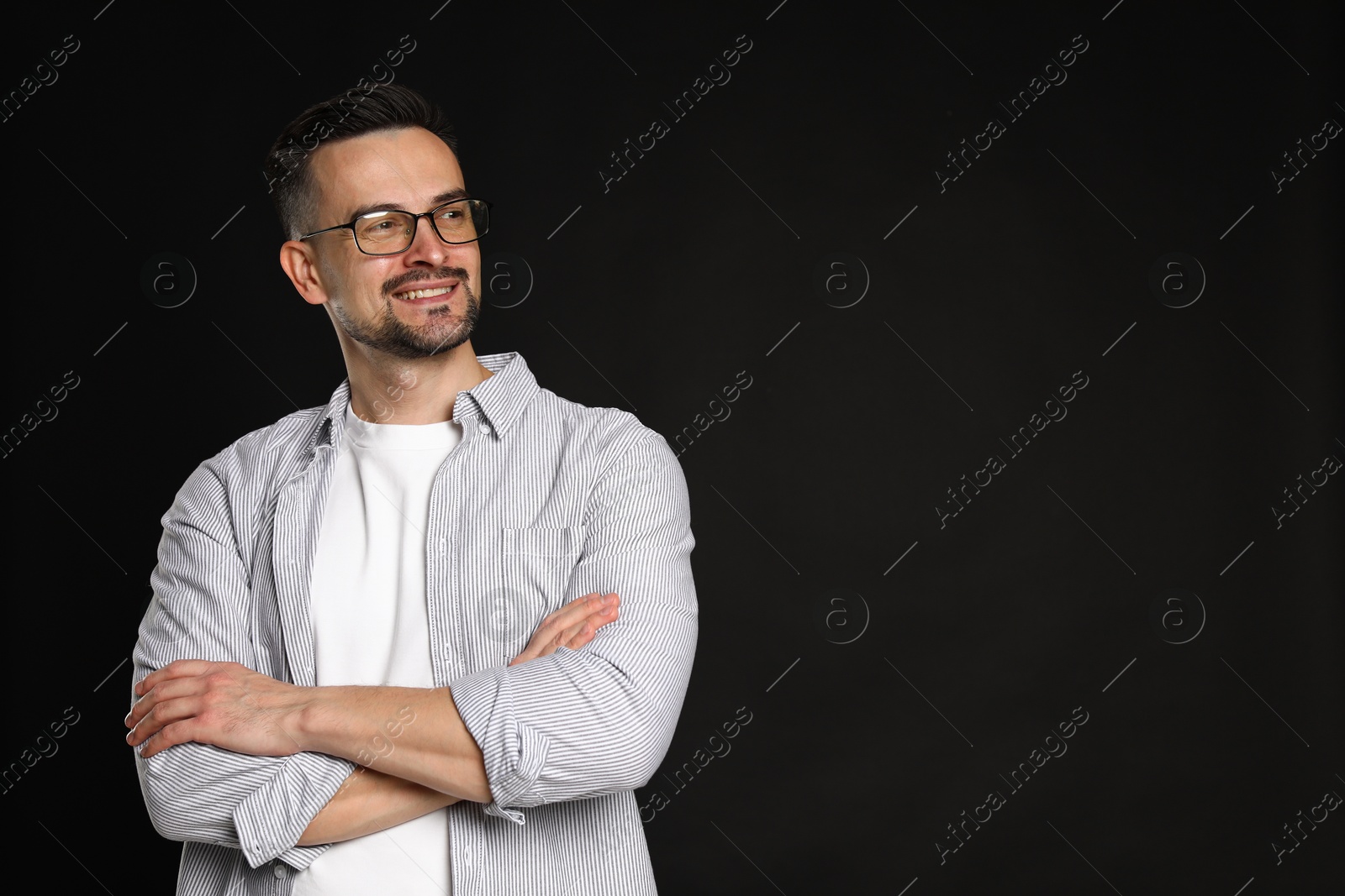 Photo of Portrait of handsome middle aged man on black background, space for text