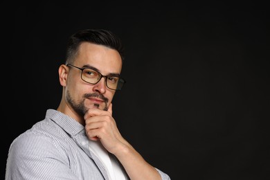 Photo of Portrait of handsome middle aged man on black background, space for text