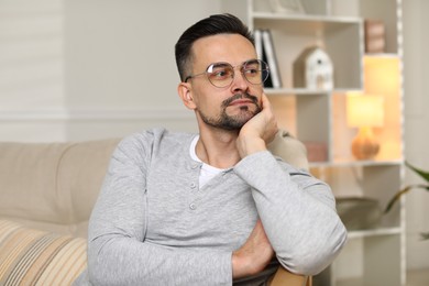 Photo of Handsome middle aged man on sofa indoors