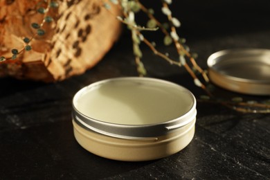 Photo of Natural solid perfume on black table, closeup