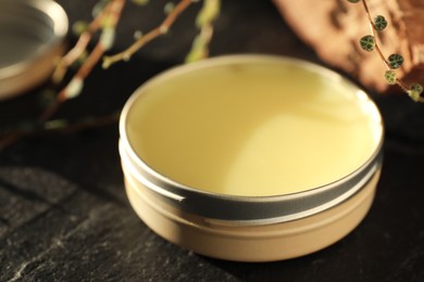 Photo of Natural solid perfume on black table, closeup