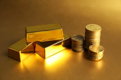 Photo of Gold bars and coins on shiny background, closeup