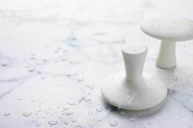 Photo of Wet spa stones on white marble table, closeup. Space for text