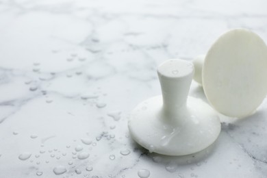 Photo of Wet spa stones on white marble table, closeup. Space for text