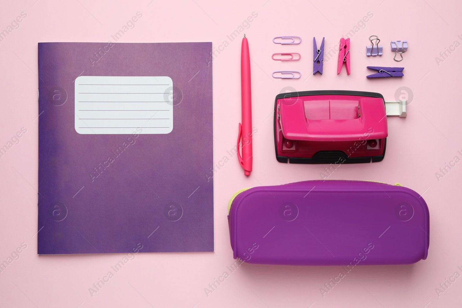 Photo of Copybook and other school stationery on pink background, flat lay