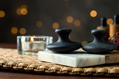 Photo of Spa stones and burning candle on table, closeup