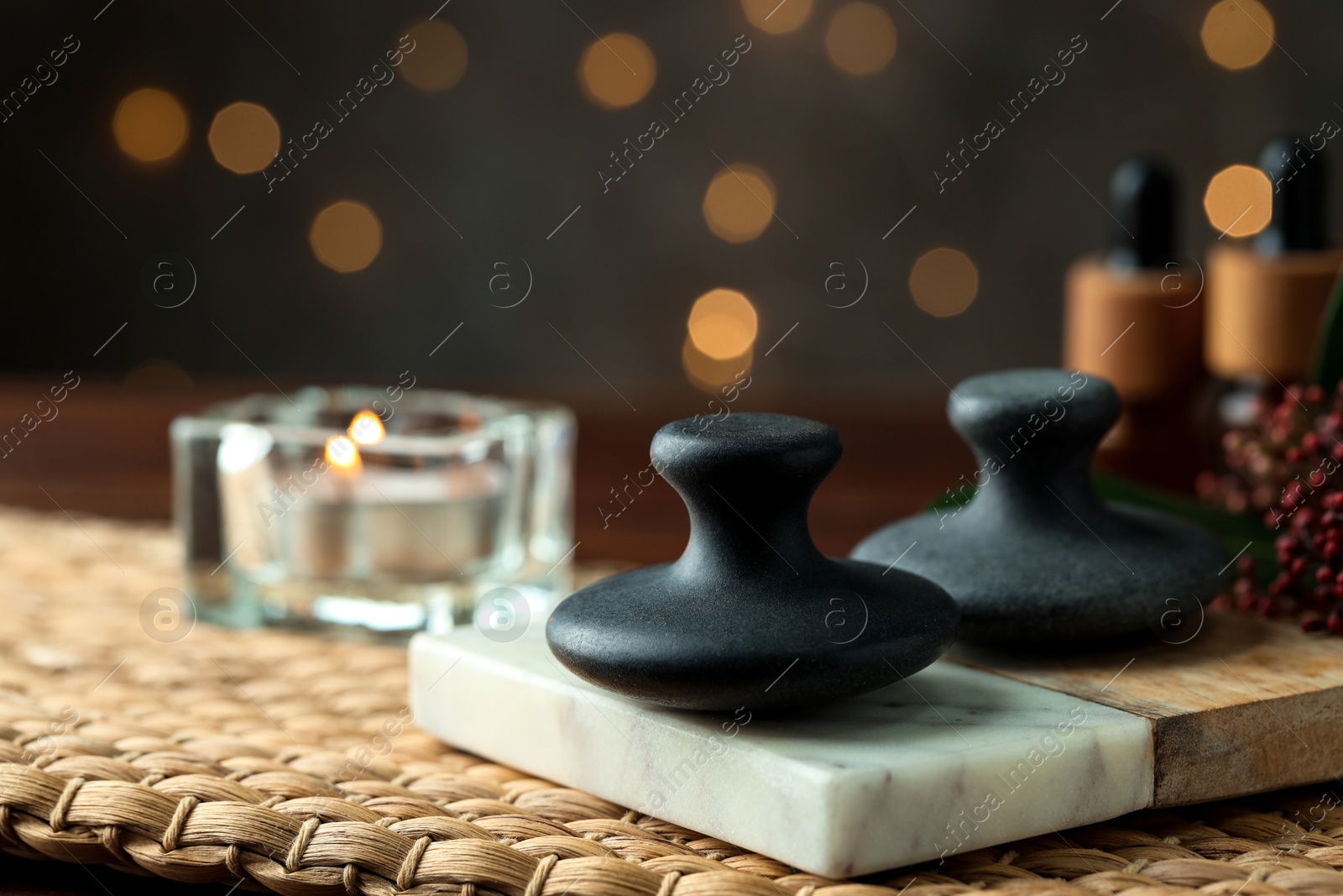 Photo of Spa stones and burning candle on table, closeup