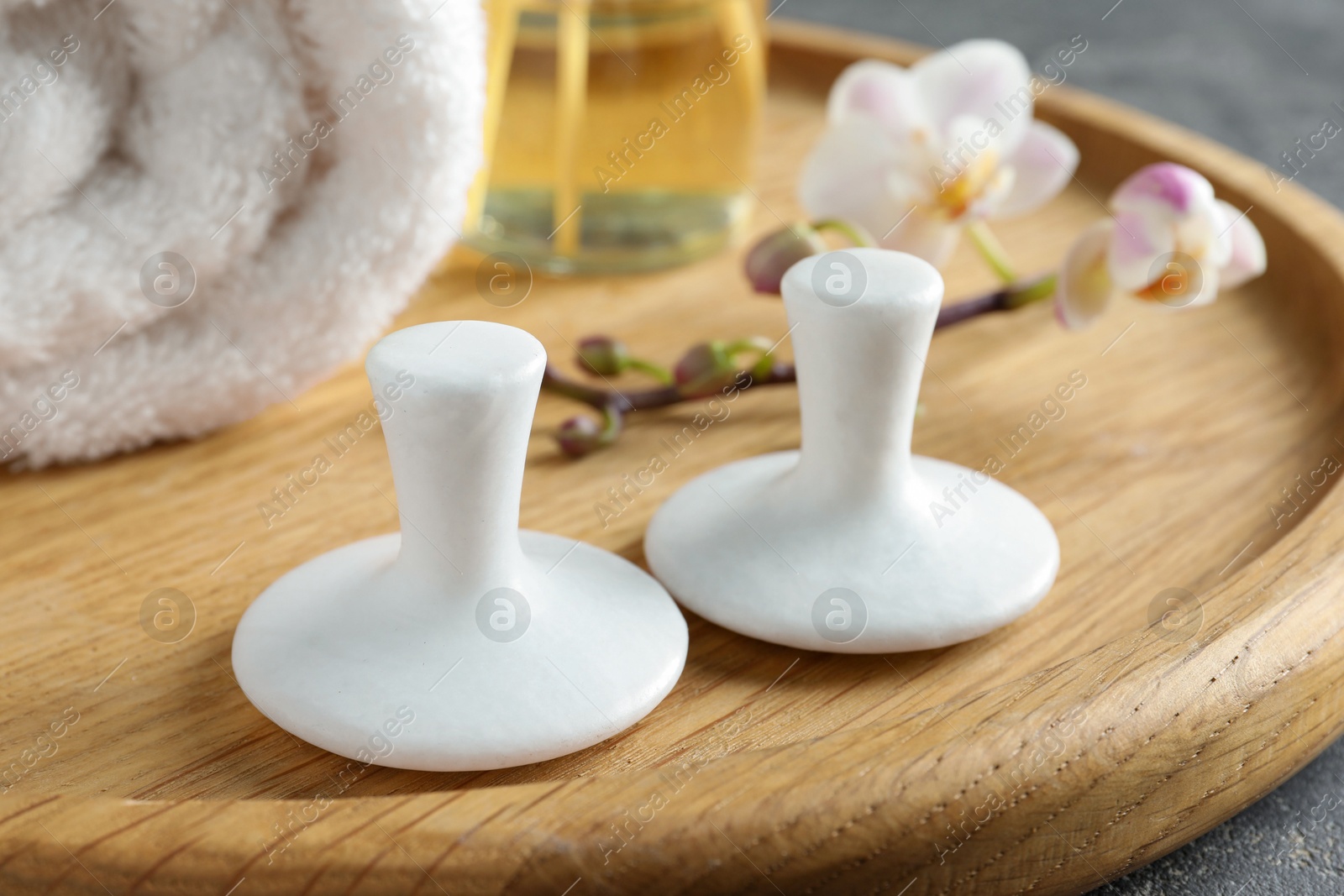 Photo of Spa stones, orchid branch and towel on table, closeup