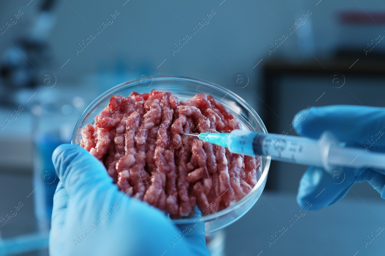 Photo of GMO concept. Scientist injecting something into minced meat in laboratory, closeup