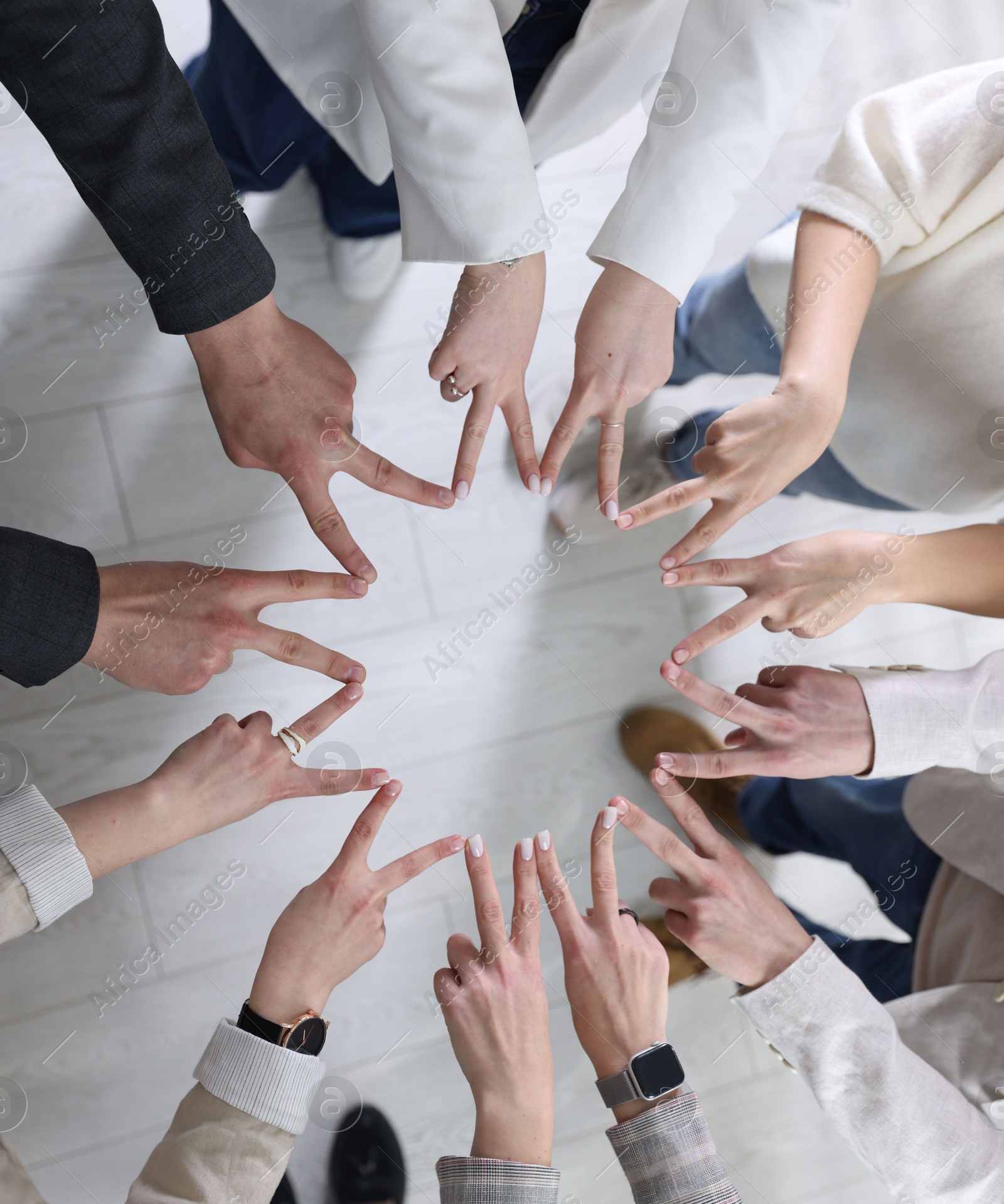 Photo of Unity concept. People showing V-sign with both hands and joining their fingers together in circle