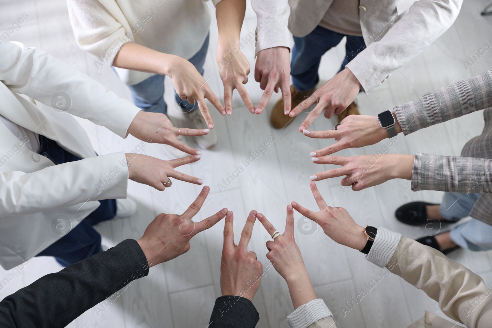 Photo of Unity concept. People showing V-sign with both hands and joining their fingers together in circle