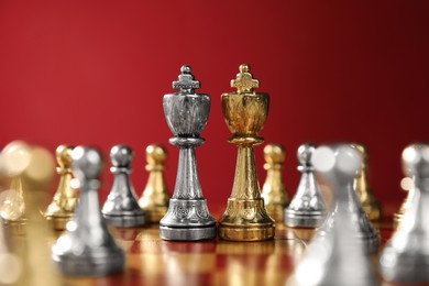 Photo of Golden and silver chess kings among pawns on chessboard. Competition concept