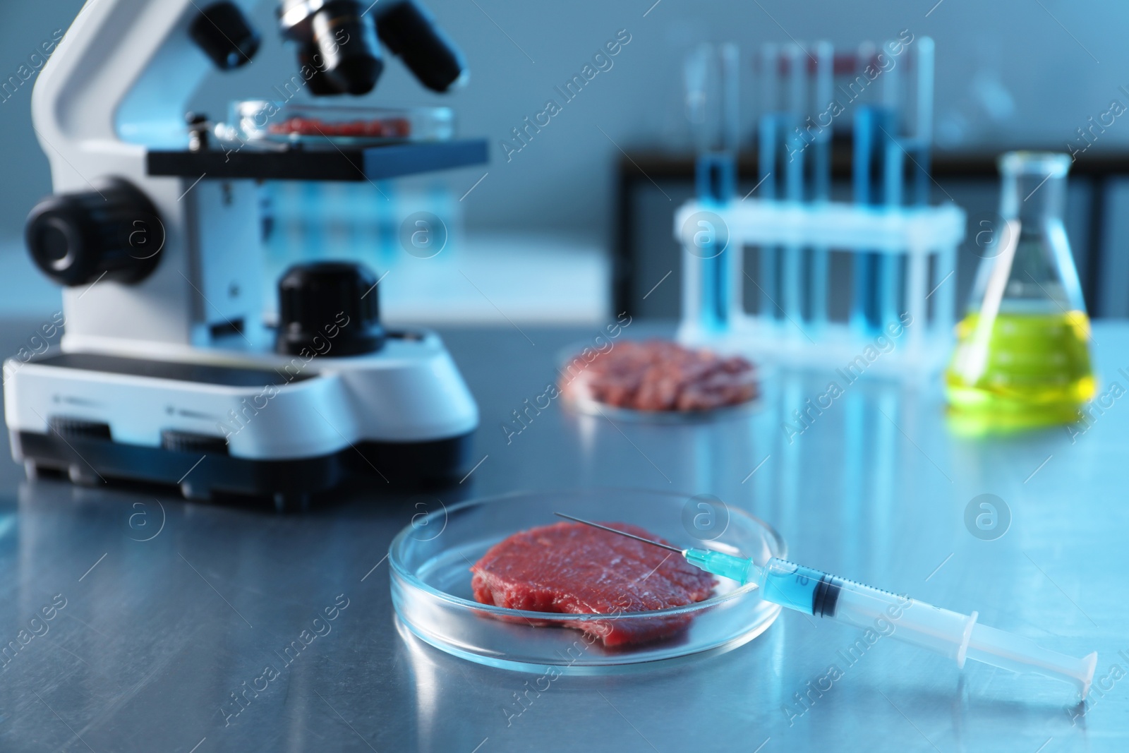 Photo of GMO concept. Minced meat and syringe on table in laboratory