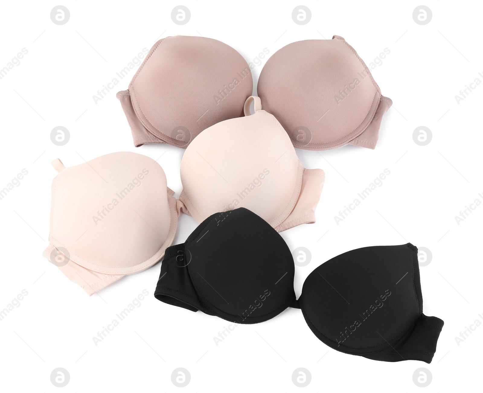 Photo of Three different beautiful bras isolated on white, top view