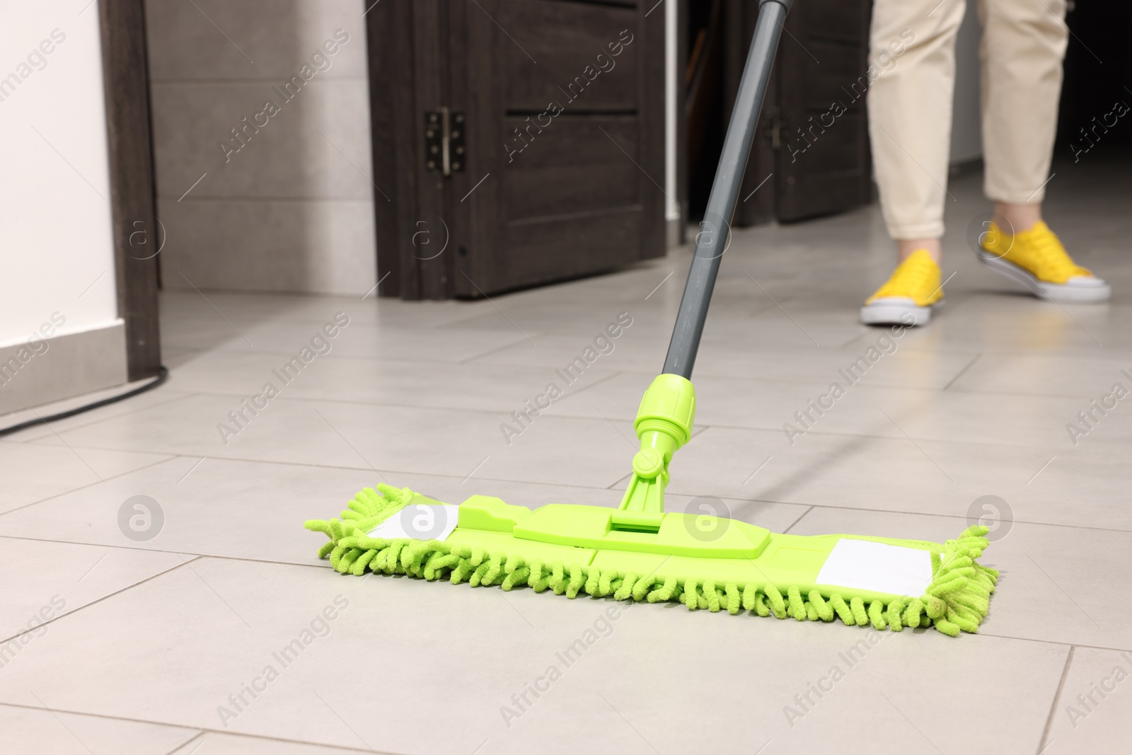 Photo of Woman cleaning floor with microfiber mop indoors, closeup