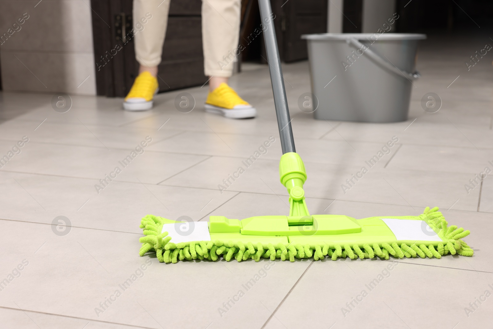 Photo of Woman cleaning floor with microfiber mop indoors, closeup