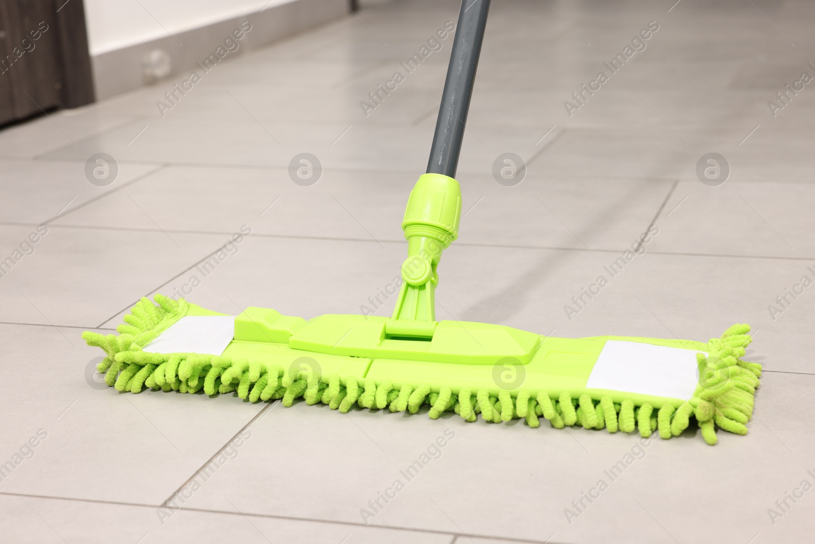 Photo of Cleaning floor with bright microfiber mop indoors