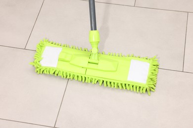 Photo of Cleaning floor with bright microfiber mop indoors