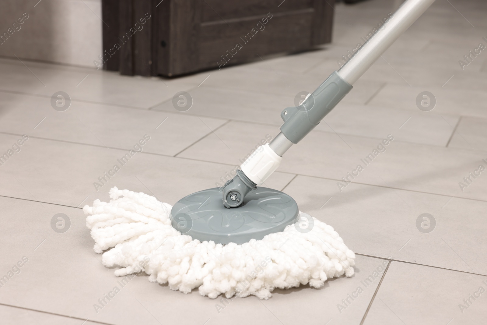 Photo of String mop on floor indoors. Cleaning equipment