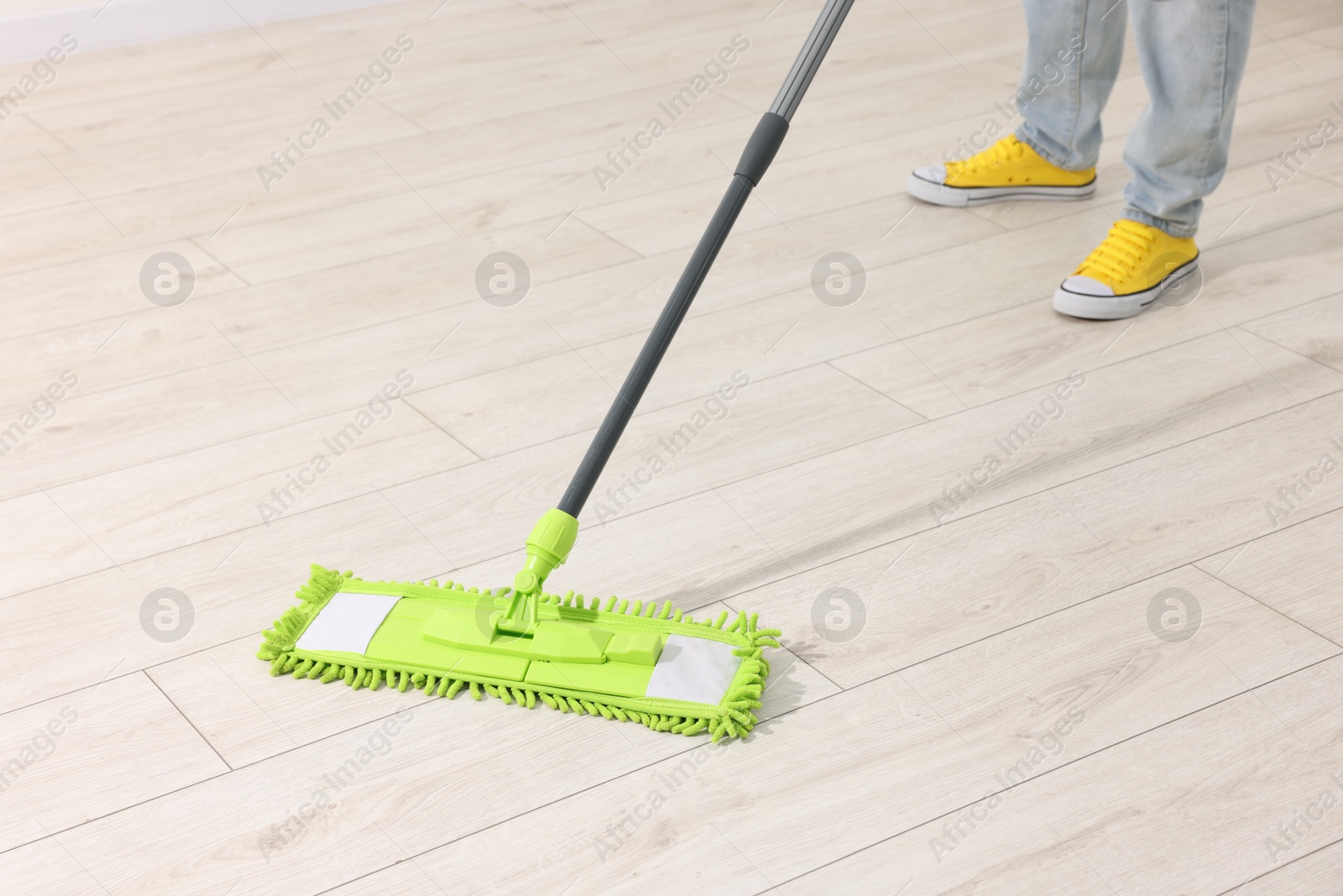 Photo of Woman cleaning floor with microfiber mop indoors, closeup