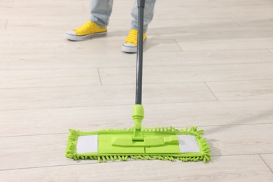 Photo of Woman cleaning floor with microfiber mop indoors, closeup