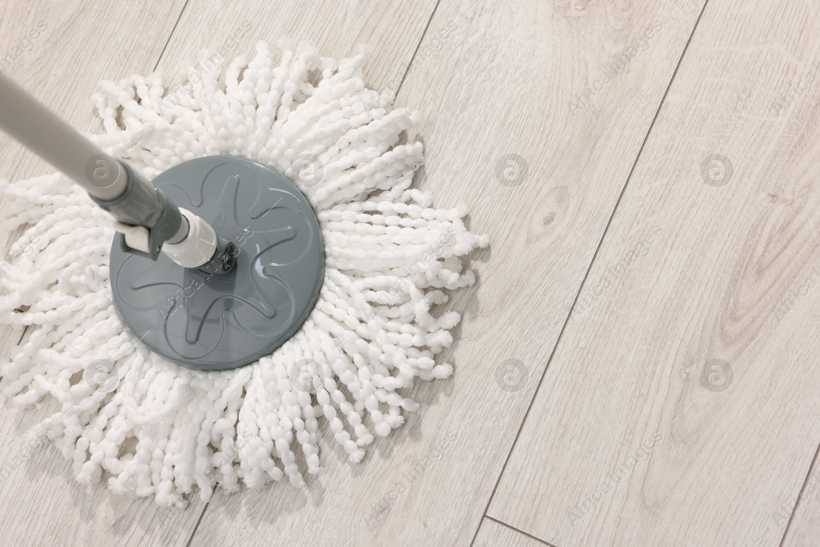 Photo of String mop on wooden floor indoors, above view. Space for text