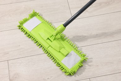 Photo of Microfiber mop on wooden floor indoors, above view