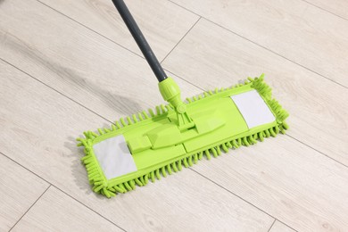 Photo of Microfiber mop on wooden floor indoors, above view