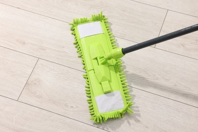 Photo of Microfiber mop on wooden floor, above view