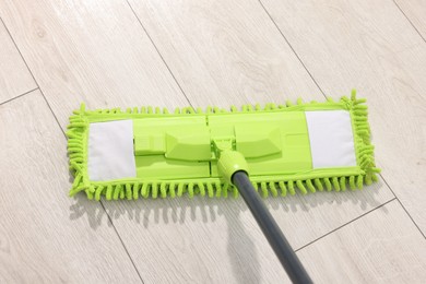 Photo of Microfiber mop on wooden floor, above view